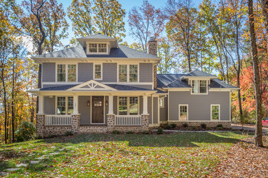 Mid-sized traditional gray two-story concrete fiberboard house exterior idea in Other with a hip roof and a shingle roof