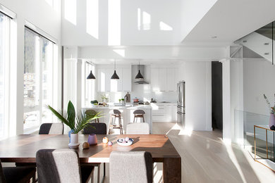 Large trendy brown floor great room photo in Vancouver with white walls