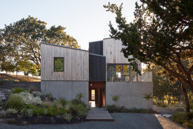 Example of a 1950s beige two-story wood house exterior design in San Francisco with a metal roof and a black roof