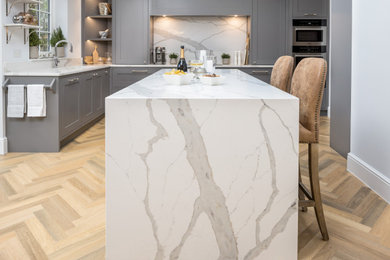 This is an example of a contemporary kitchen in Berkshire with shaker cabinets, grey cabinets and an island.