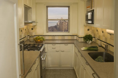 Inspiration for a small transitional galley enclosed kitchen remodel in New York with a drop-in sink, recessed-panel cabinets, white cabinets, stainless steel appliances, no island, laminate countertops, multicolored backsplash and porcelain backsplash