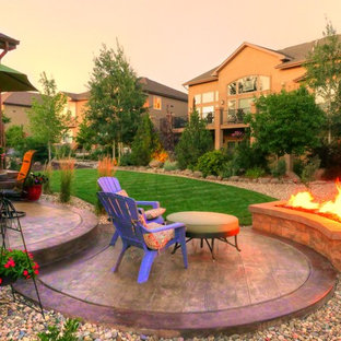 Small eclectic backyard patio in Denver with a fire feature, stamped concrete and no cover.