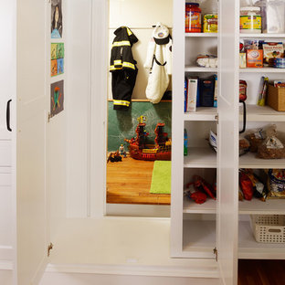 Kleine Klassische Küche in U-Form mit Vorratsschrank, weißen Schränken, braunem Holzboden und Schrankfronten im Shaker-Stil in Sonstige