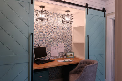 Modelo de despacho actual pequeño con paredes azules, escritorio empotrado y papel pintado