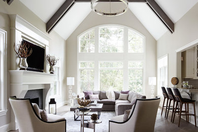 Example of a large transitional open concept medium tone wood floor living room design in Chicago with a bar, a standard fireplace, a wall-mounted tv, beige walls and a stone fireplace