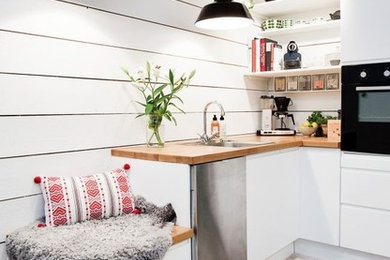 Photo of a small scandinavian l-shaped kitchen in San Francisco with a drop-in sink, flat-panel cabinets, white cabinets and white splashback.