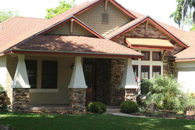 Large trendy beige one-story stone exterior home photo in Orlando