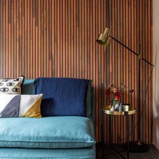 Inspiration for a medium sized bohemian look-out basement in London with pink walls, concrete flooring, no fireplace, a plastered fireplace surround and grey floors.