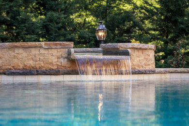 Diseño de piscinas y jacuzzis campestres de tamaño medio tipo riñón en patio trasero con adoquines de piedra natural