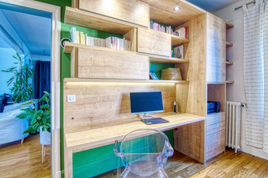 Cette image montre un bureau design de taille moyenne avec un mur vert, parquet clair, aucune cheminée, un bureau intégré et un sol marron.
