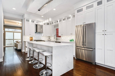 Inspiration for a transitional l-shaped kitchen in Chicago with shaker cabinets, white cabinets and with island.