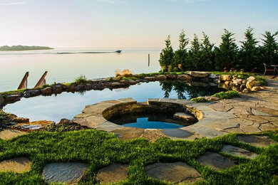 Example of a mid-sized transitional backyard stone and rectangular natural hot tub design in New York