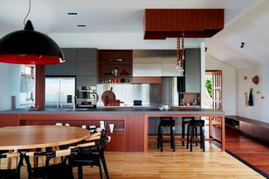 Arts and crafts eat-in kitchen in Brisbane with stainless steel appliances and light hardwood floors.