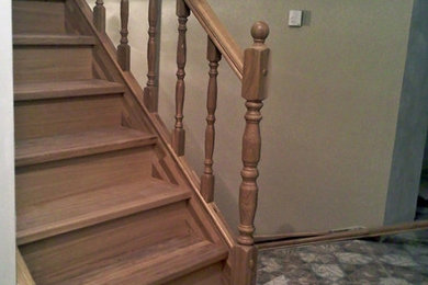 На фото: п-образная деревянная лестница среднего размера с деревянными ступенями и деревянными перилами