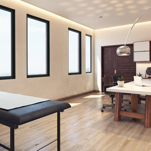 Photo of a small modern study in Other with white walls, terracotta flooring, a freestanding desk and beige floors.