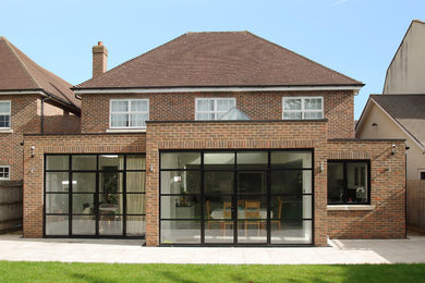Inspiration for a large contemporary one-storey brick brown house exterior with a flat roof.