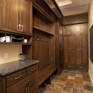 Walk-in closet - mid-sized rustic gender-neutral terra-cotta floor walk-in closet idea in Minneapolis with shaker cabinets and dark wood cabinets
