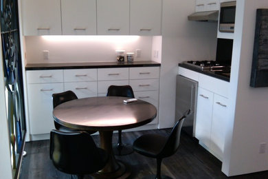 Mid-sized transitional dark wood floor and black floor great room photo in Los Angeles with white walls and no fireplace