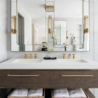 Large trendy white tile terrazzo floor and gray floor bathroom photo in New York with furniture-like cabinets, medium tone wood cabinets, an integrated sink and white countertops