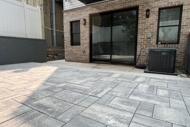 Inspiration for a small contemporary backyard concrete paver patio remodel in Newark