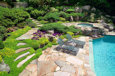 Design ideas for a large traditional backyard custom-shaped lap pool in New York with natural stone pavers and a hot tub.