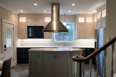 This is an example of a large transitional l-shaped open plan kitchen in Houston with a farmhouse sink, recessed-panel cabinets, blue cabinets, quartz benchtops, grey splashback, marble splashback, stainless steel appliances, porcelain floors, with island and grey floor.