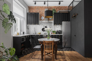 Design ideas for an industrial l-shaped open plan kitchen in Moscow with raised-panel cabinets, black cabinets, white splashback, subway tile splashback, stainless steel appliances and no island.