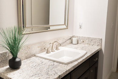 Bathroom - traditional bathroom idea in Other with brown cabinets, a drop-in sink and granite countertops