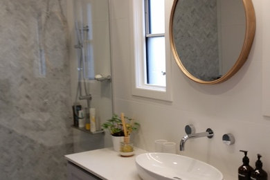 Пример оригинального дизайна: главная ванная комната среднего размера в скандинавском стиле с фасадами в стиле шейкер, серыми фасадами, открытым душем, белой плиткой, белыми стенами, полом из сланца, настольной раковиной, мраморной столешницей, серым полом, открытым душем, белой столешницей, инсталляцией и мраморной плиткой