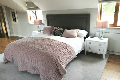 Inspiration for a large contemporary mezzanine bedroom in Cornwall with grey walls and medium hardwood flooring.