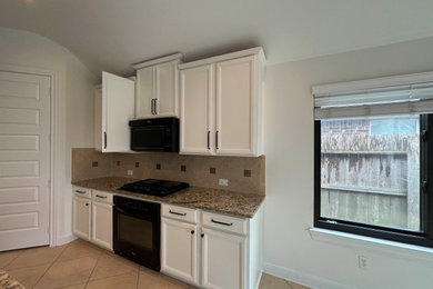 Kitchen - mid-sized traditional single-wall kitchen idea in Houston with white cabinets, colored appliances, no island and recessed-panel cabinets