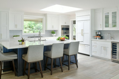 Inspiration for a coastal l-shaped brown floor eat-in kitchen remodel in Atlanta with an undermount sink, flat-panel cabinets, white cabinets, quartz countertops, multicolored backsplash, paneled appliances, an island and white countertops