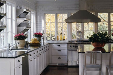 Inspiration for a mid-sized industrial l-shaped dark wood floor and brown floor enclosed kitchen remodel in Birmingham with a drop-in sink, shaker cabinets, white cabinets, soapstone countertops, white backsplash, subway tile backsplash, stainless steel appliances and an island