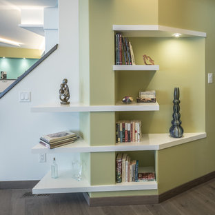 Inspiration for a medium sized contemporary walk-out basement in Other with green walls, dark hardwood flooring, a wood burning stove, a tiled fireplace surround and grey floors.