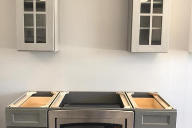 Eat-in kitchen - mid-sized traditional l-shaped laminate floor, gray floor and coffered ceiling eat-in kitchen idea in Seattle with a double-bowl sink, shaker cabinets, gray cabinets, quartzite countertops, stainless steel appliances, an island and multicolored countertops