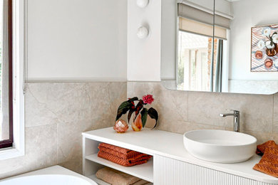 Design ideas for a small contemporary 3/4 bathroom in Melbourne with white cabinets, a corner tub, beige tile, porcelain tile, porcelain floors, engineered quartz benchtops, beige floor, white benchtops, a single vanity, a floating vanity, open cabinets, grey walls and a vessel sink.