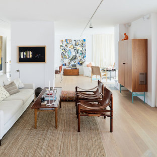 Foto på ett stort funkis allrum med öppen planlösning, med ett finrum, vita väggar och ljust trägolv