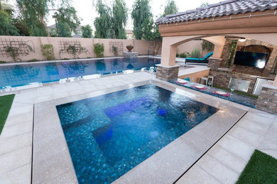 Photo of a mid-sized contemporary backyard rectangular lap pool in Orange County with a hot tub and natural stone pavers.