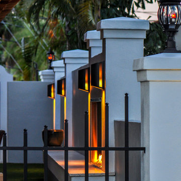 Walled-in outdoor covered lanai with custom fireplace and artificial greens