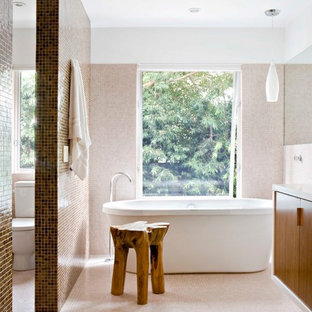 Foto di una stanza da bagno minimalista con ante lisce, ante in legno scuro, vasca freestanding, WC a due pezzi, piastrelle beige, piastrelle a mosaico, pareti bianche e pavimento con piastrelle a mosaico