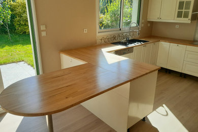 Cette image montre une cuisine ouverte traditionnelle avec un plan de travail en bois.