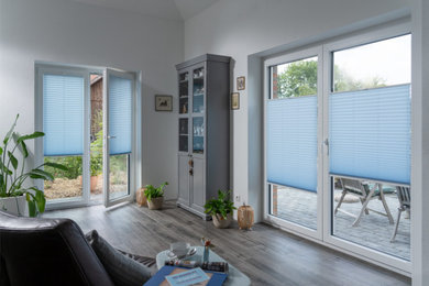Landhausstil Wohnzimmer in grau-weiß mit weißer Wandfarbe, Keramikboden, braunem Boden und Tapetendecke in Frankfurt am Main