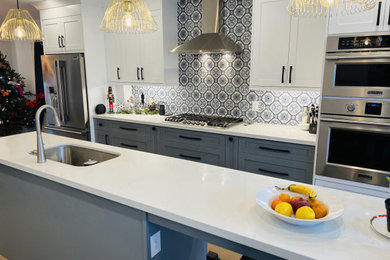 Inspiration for a mid-sized contemporary galley medium tone wood floor and brown floor open concept kitchen remodel in Toronto with a single-bowl sink, shaker cabinets, gray cabinets, quartz countertops, blue backsplash, cement tile backsplash, stainless steel appliances, an island and white countertops