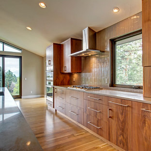 Inspiration for a large contemporary galley kitchen pantry in Denver with an undermount sink, flat-panel cabinets, medium wood cabinets, granite benchtops, beige splashback, ceramic splashback, stainless steel appliances, light hardwood floors, with island and brown floor.