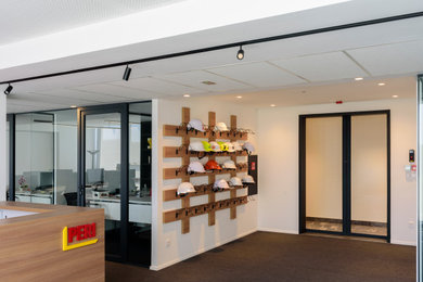 Idées déco pour un hall d'entrée contemporain de taille moyenne avec un mur blanc, moquette, une porte coulissante, une porte en verre et un sol noir.