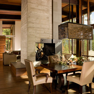 Idéer för en stor rustik matplats med öppen planlösning, med beige väggar, mellanmörkt trägolv, en dubbelsidig öppen spis och en spiselkrans i betong