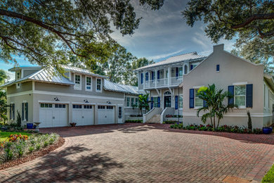 Example of a large classic gray two-story mixed siding house exterior design in Tampa with a hip roof and a metal roof