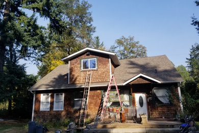 Mid-sized elegant brown two-story wood and shingle house exterior photo in Seattle with a gambrel roof, a shingle roof and a gray roof