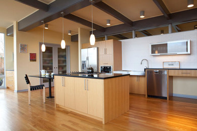 Design ideas for a large midcentury galley eat-in kitchen in Seattle with flat-panel cabinets, light wood cabinets, granite benchtops, stainless steel appliances, white splashback, medium hardwood floors and with island.