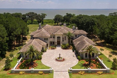 Expansive traditional two-storey grey exterior in Orlando with stone veneer and a hip roof.